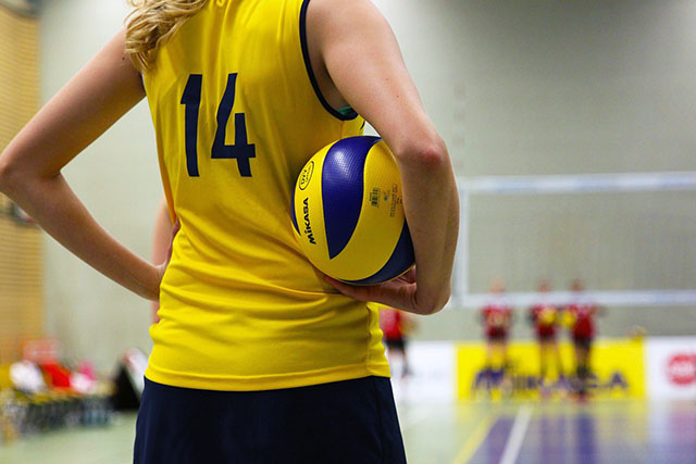 a girl holding a volleyball