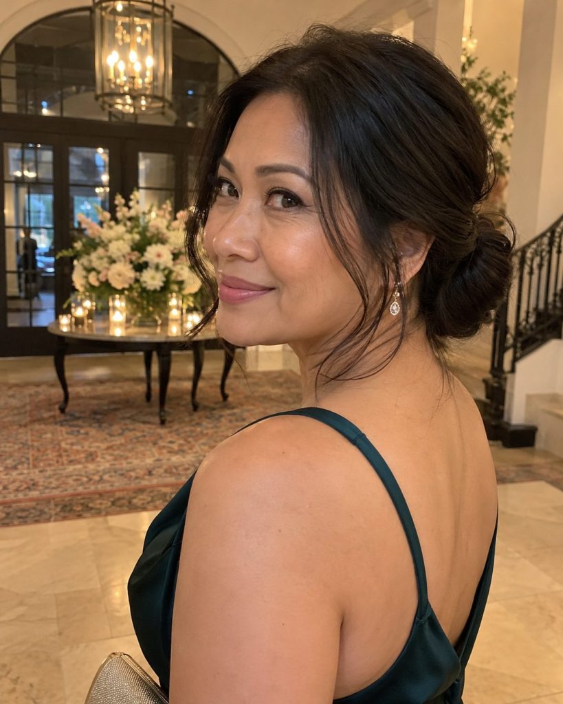 Soft low chignon with loose face-framing strands worn at an indoor evening event
